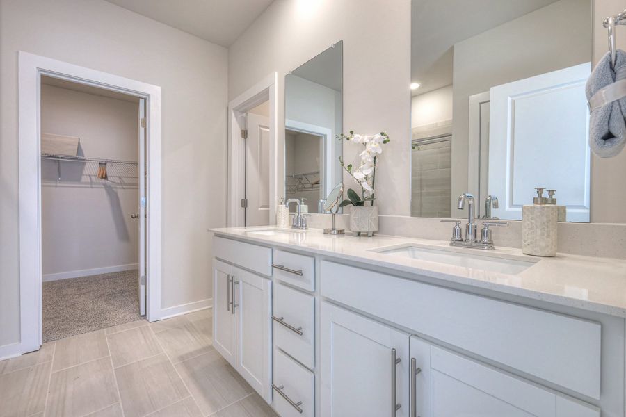 The primary bathroom offers dual vanity sinks and a walk-in shower. The primary bathroom offers dual vanity sinks and a walk-in shower.