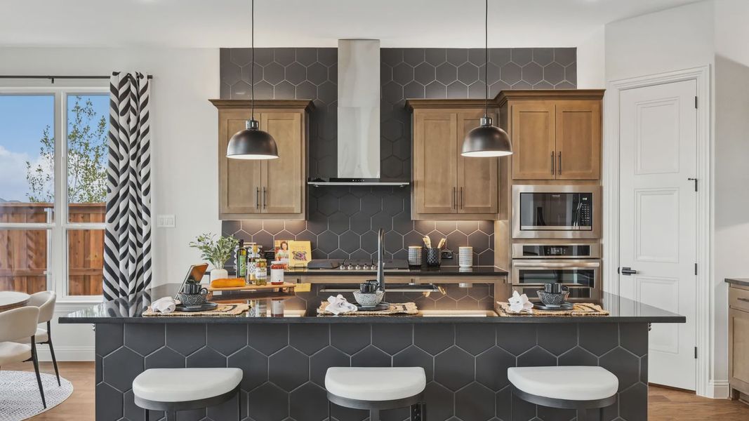 Sophisticated kitchen with sleek black hexagonal tiles and custom wood cabinetry in Green Meadows. Sophisticated kitchen with sleek black hexagonal tiles and custom wood cabinetry in Green Meadows.