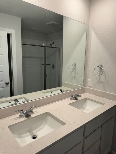 A modern bathroom features a dual-sink vanity, large mirror, and glass-enclosed shower, creating a sleek and functional space. A modern bathroom features a dual-sink vanity, large mirror, and glass-enclosed shower, creating a sleek and functional space.