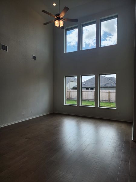 A spacious living room with high ceilings, large windows, and a ceiling fan, offering ample natural light and an airy feel. A spacious living room with high ceilings, large windows, and a ceiling fan, offering ample natural light and an airy feel.