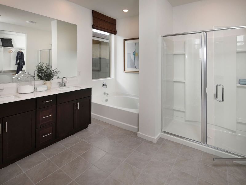 Walk-in shower, bath, and dual sinks in the primary bathroom