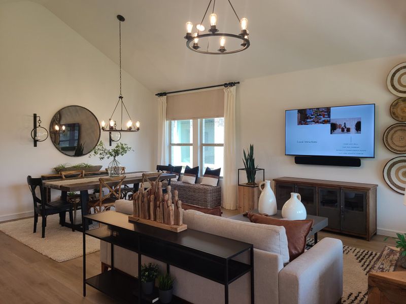 A cozy living and dining area with elegant lighting, rustic wooden table, and modern wall décor. A cozy living and dining area with elegant lighting, rustic wooden table, and modern wall décor.