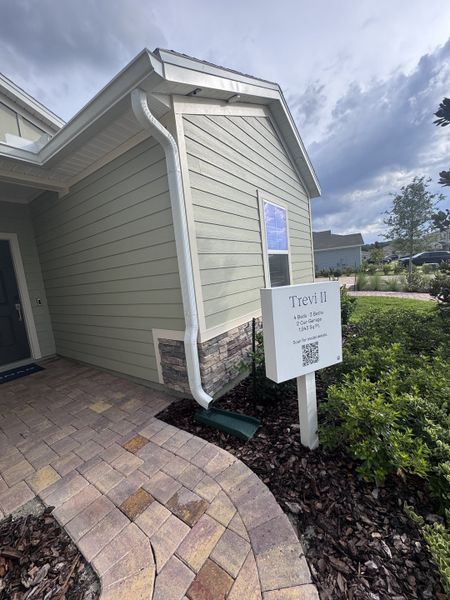 A charming sage green home with stone accents and paver walkway in Trailmark by Lennar, St. Augustine, FL.