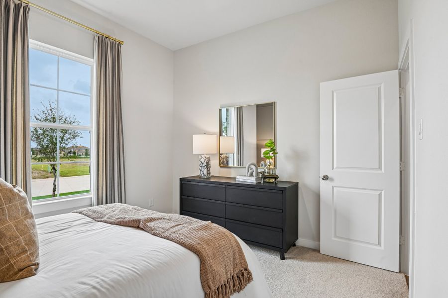 A bedroom with a large window.
