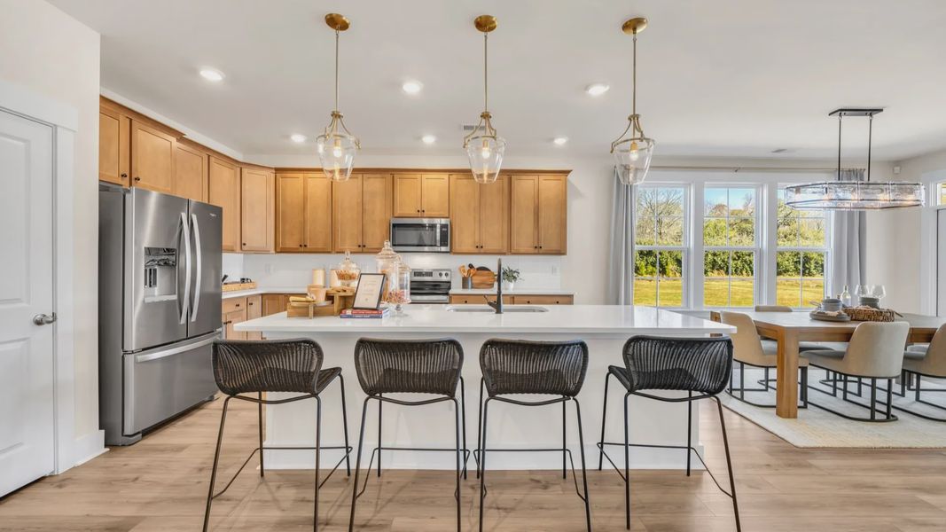 Kitchen in Chestnut Farms in by DRB homes offering an open layout with a kitchen island and amazing light fixtures