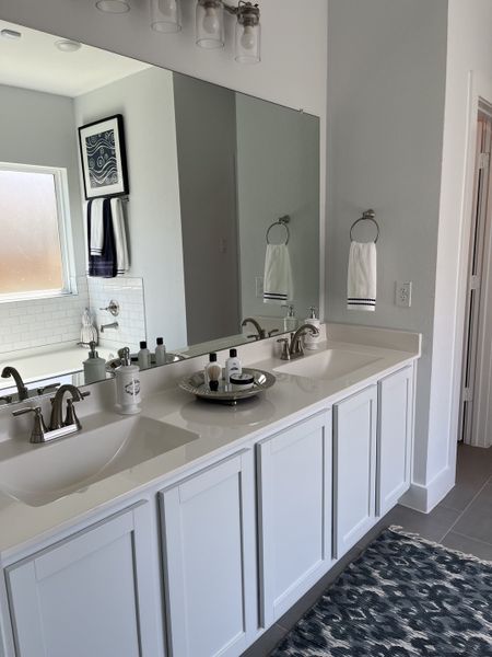 A modern bathroom with a dual-sink vanity, sleek fixtures, and stylish decor.