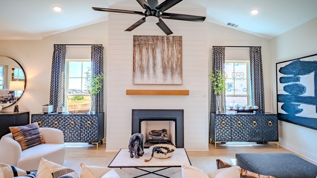 Gathering area with high ceilings, ceiling fan, and fireplace