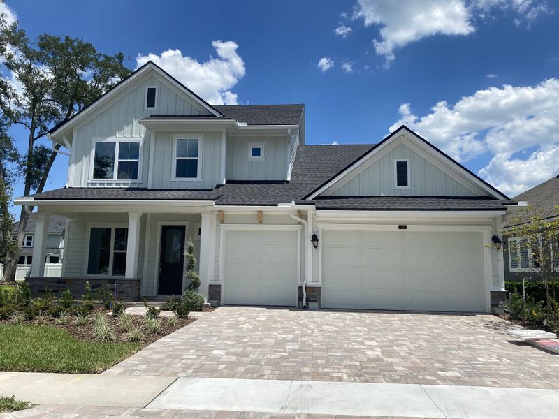 A charming light-blue house with a spacious driveway in Evergreen Island at Silverleaf by David Weekley Homes (St. Augustine, FL).