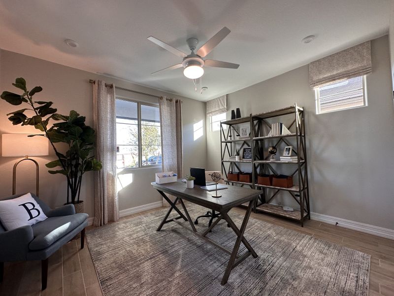 A modern home office featuring a large window, elegant desk, chic shelving, and cozy seating with accent lighting.