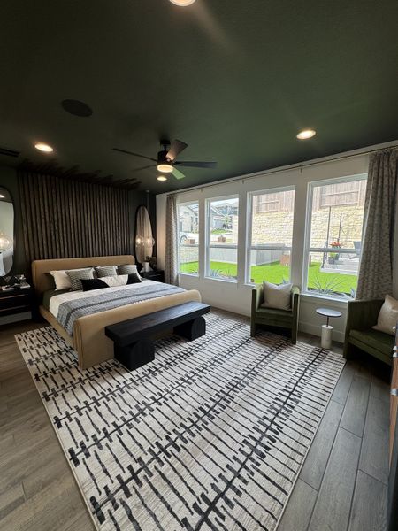 A modern bedroom featuring a cozy bed, stylish patterned rug, and large windows offering abundant natural light. A modern bedroom featuring a cozy bed, stylish patterned rug, and large windows offering abundant natural light.