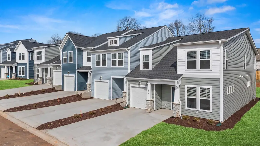 Two story townhome with two car driveway, one car garage, and large windows with light blue exterior at Aspen Ridge Two story townhome with two car driveway, one car garage, and large windows with light blue exterior at Aspen Ridge