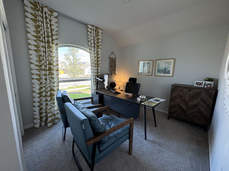 A cozy home office with patterned curtains, blue chairs, and a sleek desk, creating an inviting workspace atmosphere. A cozy home office with patterned curtains, blue chairs, and a sleek desk, creating an inviting workspace atmosphere.
