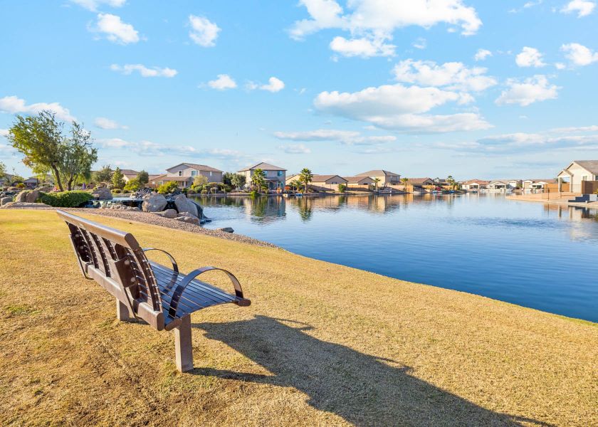 A bench sits by a body of water.