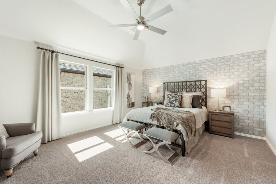 Master bedroom with vaulted ceiling, exposed brick accent wall, ceiling fan, and carpet flooring Master bedroom with vaulted ceiling, exposed brick accent wall, ceiling fan, and carpet flooring
