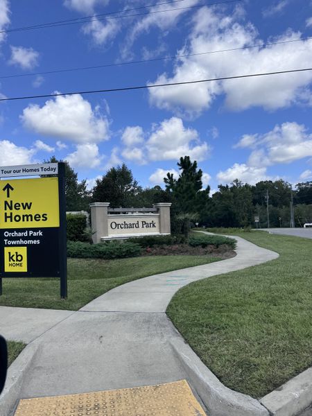 Welcome to Orchard Park Townhomes by KB Home in St. Augustine, FL, featuring lush greenery and inviting pathways.