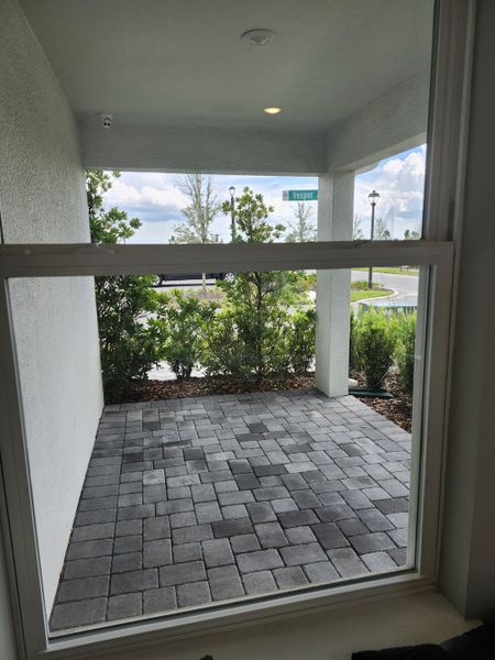 A cozy covered patio with brick pavers and garden view. Perfect for relaxation in EverBe by Pulte Homes (Orlando, FL). A cozy covered patio with brick pavers and garden view. Perfect for relaxation in EverBe by Pulte Homes (Orlando, FL).