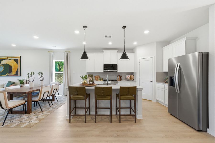 A kitchen with a dining table and a refrigerator. A kitchen with a dining table and a refrigerator.