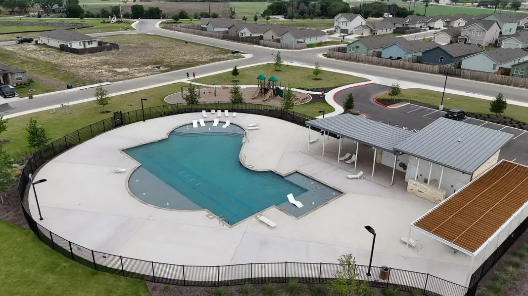 A modern community pool and playground in Parkside: Watermill Collection by Lennar, New Braunfels, TX. Ideal for family relaxation.