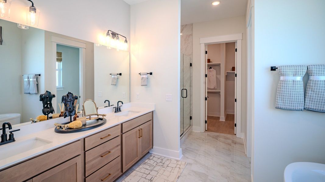 bathroom with dual vanity and access to closet