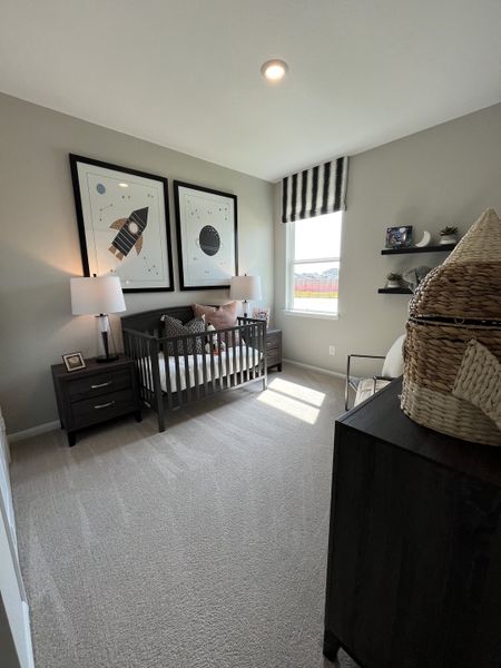 A cozy nursery with a dark wood crib, playful wall art, and soft carpeting, bathed in natural light. A cozy nursery with a dark wood crib, playful wall art, and soft carpeting, bathed in natural light.