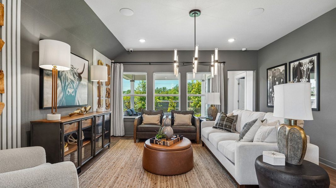 Great Room features a modern chandelier in the center of the room and is open to the kitchen and dining area.