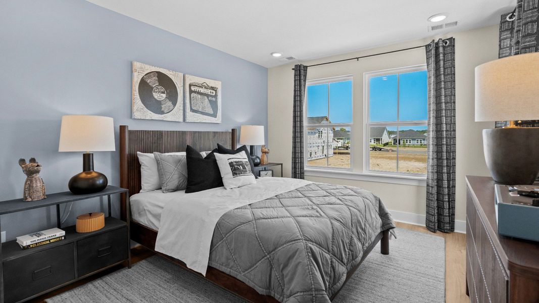 Second-floor secondary bedroom in the Summit home plan with bright windows and comfort.
