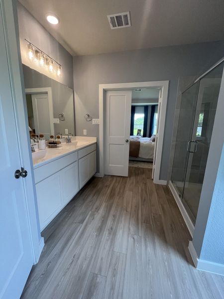 A modern bathroom with sleek gray flooring, elegant dual vanity, and chic lighting. A modern bathroom with sleek gray flooring, elegant dual vanity, and chic lighting.