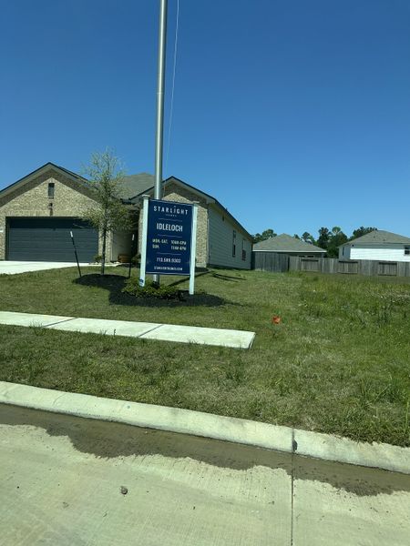 A modern brick home with a spacious yard in Idleloch by Starlight Homes, located in Huffman, TX.