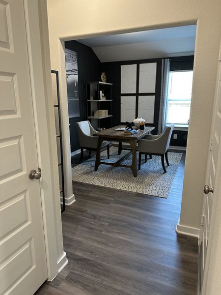 A cozy study with wood flooring, modern furnishings, and natural light through a large window. A cozy study with wood flooring, modern furnishings, and natural light through a large window.