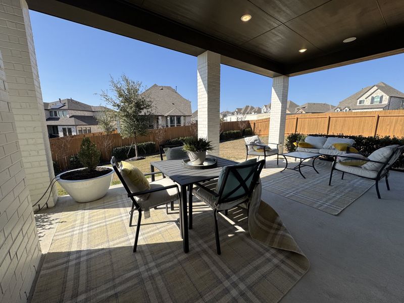 A spacious outdoor patio with cozy seating, potted plants, and a charming view of a suburban neighborhood. A spacious outdoor patio with cozy seating, potted plants, and a charming view of a suburban neighborhood.