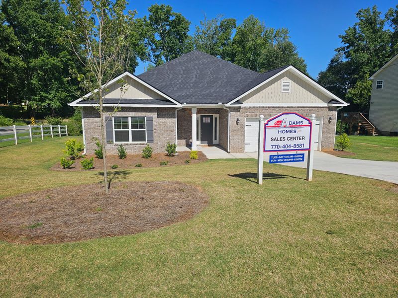 A charming brick home with lush landscaping in Scarlett Place by Adams Homes (Bowdon, GA).