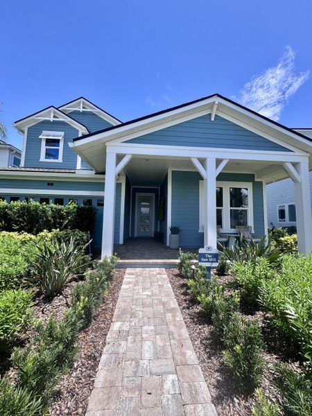 A charming blue home with lush landscaping in Reflections 50' Front Load by David Weekley Homes (Ponte Vedra Beach, FL).