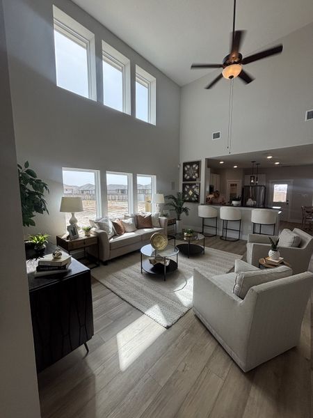 A stunning living space with soaring ceilings, abundant natural light from large windows, and a ceiling fan. A stunning living space with soaring ceilings, abundant natural light from large windows, and a ceiling fan.