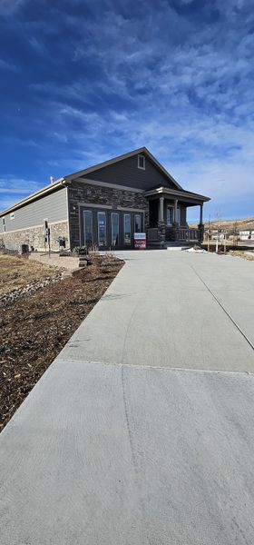 A charming stone-accented home with a spacious driveway in Rhyolite Ranch by Kauffman Homes (Castle Rock, CO).