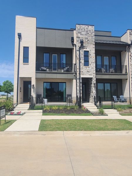 A modern townhouse with sleek lines and stone accents in The Farm by Ashton Woods (Allen, TX).