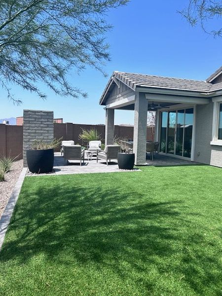 Charming backyard with a cozy patio and lush green lawn in Seasons at Rancho El Dorado IV by Richmond American Homes (Maricopa, AZ).