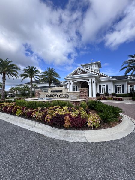 The elegant Canopy Club entrance features lush landscaping and palm trees in Del Webb Nocatee by Del Webb (Ponte Vedra, FL).