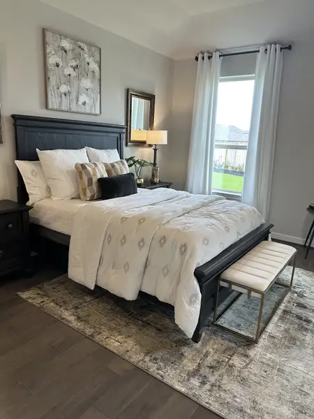 A cozy bedroom with elegant decor, featuring a dark wood bed, plush bedding, and soft lighting. A cozy bedroom with elegant decor, featuring a dark wood bed, plush bedding, and soft lighting.