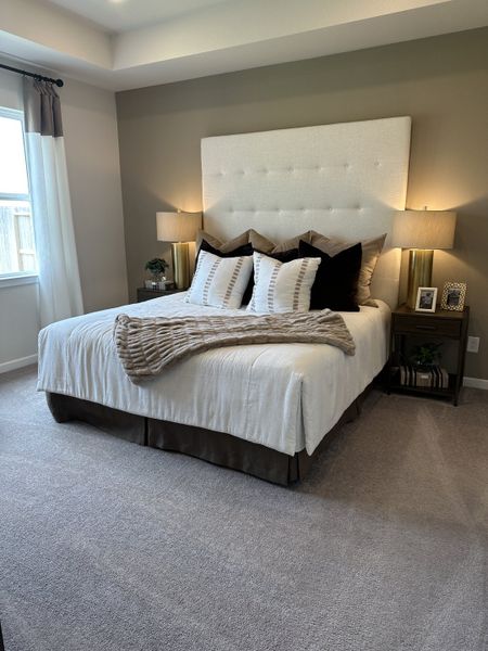 Cozy bedroom with plush carpet, tufted headboard, layered pillows, and elegant lighting, creating a serene retreat atmosphere. Cozy bedroom with plush carpet, tufted headboard, layered pillows, and elegant lighting, creating a serene retreat atmosphere.