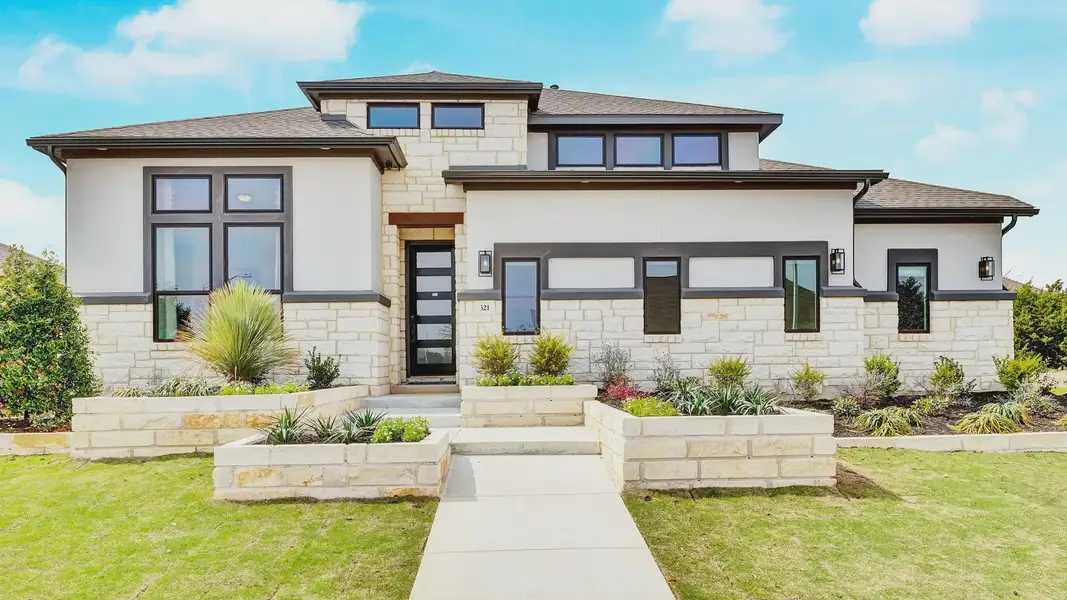 Elegant stone and stucco facade with expansive windows in Hawkes Landing. Luxurious curb appeal.
