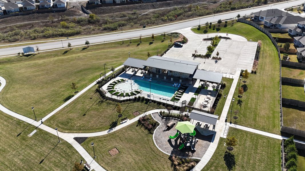 An inviting community pool and playground area in Turner's Village by Meritage Homes (Buda, TX).