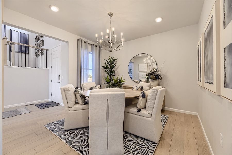 A living room with a white couch and a round mirror.
