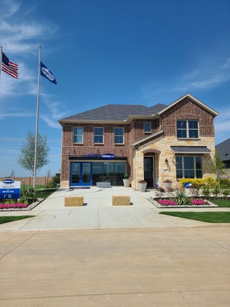 A beautiful two-story brick home with a landscaped yard in Arbors at Legacy Hills by Mattamy Homes (Celina, TX).