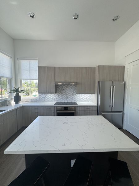 A modern kitchen featuring a marble island, sleek cabinetry, and high-end stainless steel appliances. A modern kitchen featuring a marble island, sleek cabinetry, and high-end stainless steel appliances.