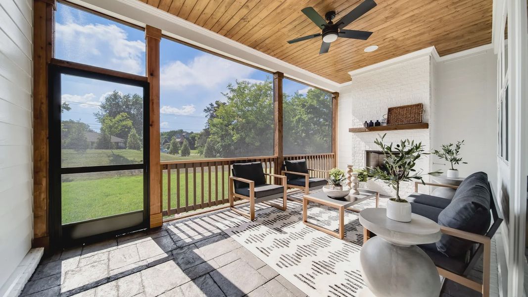 Luxurious screened porch with rich wood ceiling, stone flooring, and chic fireplace in Shelton Square, TN.
