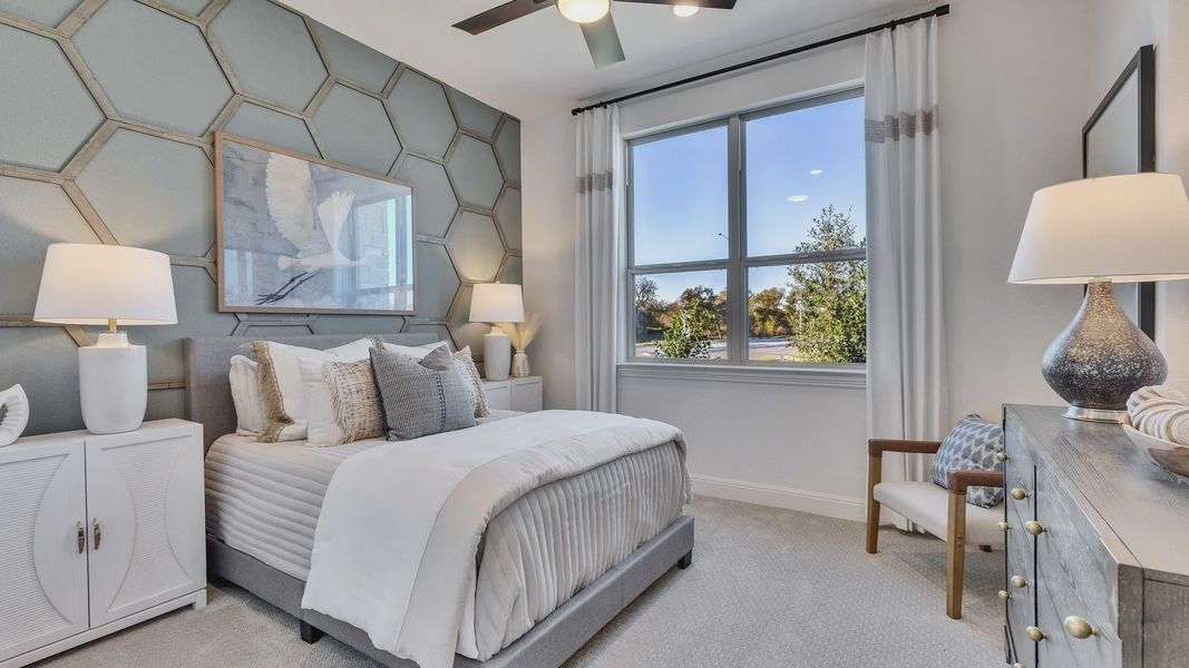 Hexagonal wall and modern décor highlight this Creeks Crossing bedroom. Luxurious window views accentuate space.