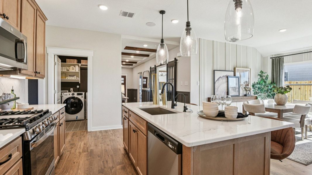 The kitchen features 42 inch wood cabinetry with industrial style pendant lighting above the center island The kitchen features 42 inch wood cabinetry with industrial style pendant lighting above the center island