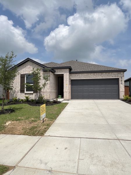 A modern brick home with a manicured lawn and spacious driveway in Heartland by KB Home (Heartland, TX). A modern brick home with a manicured lawn and spacious driveway in Heartland by KB Home (Heartland, TX).