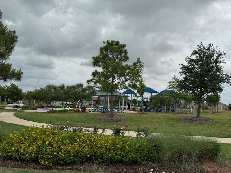 A vibrant community park with playgrounds and landscaped paths in Freeman Ranch by LGI Homes (Katy, TX).