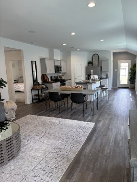 A modern open-concept kitchen and dining area with sleek cabinetry, wood flooring, and contemporary furnishings.